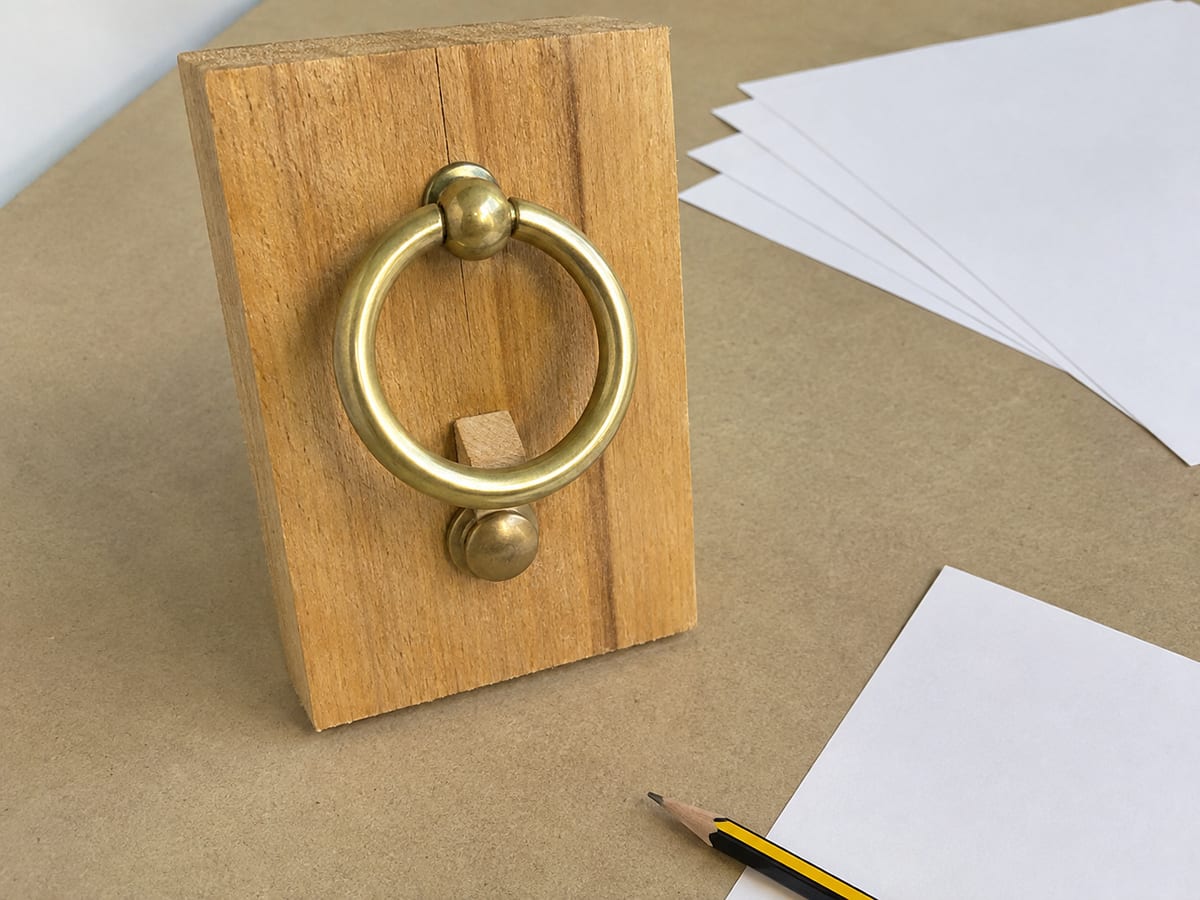 A notepad listing the four questions a business owner answers by phone every week, beside a phone showing a Google Business Profile