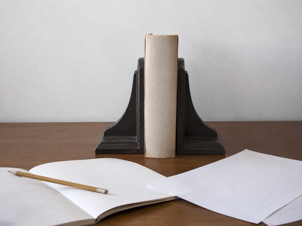 Two printed Google Maps business listings side by side on a desk, one with an address crossed out in pen and a note reading which one is current