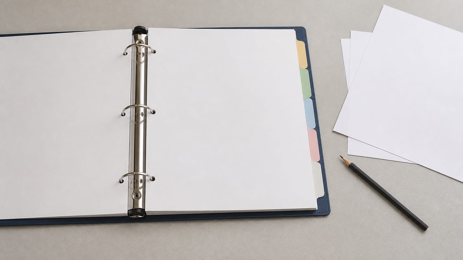 A ring binder open flat on a desk with tabbed dividers separating five thin sections, the tabs staggered so all five are readable as tabs without carrying words