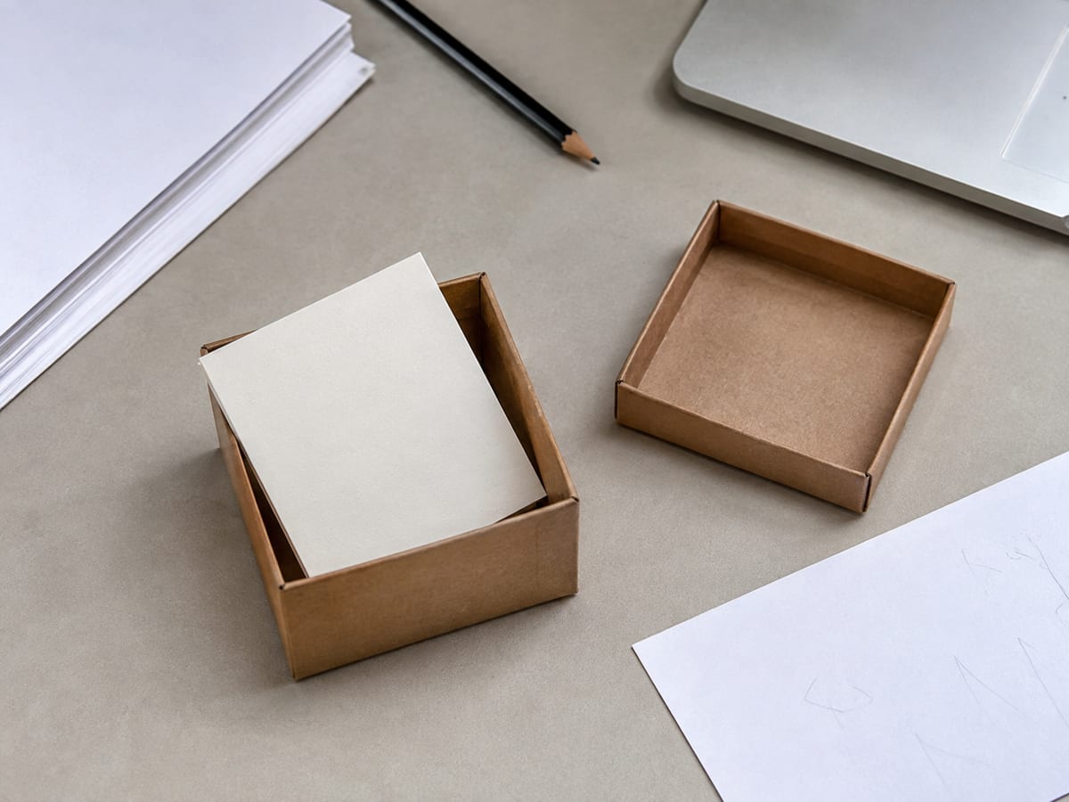 A printed handover checklist beside a laptop, with lines for source code, deployment scripts, database schema, documentation and account credentials, several ticked