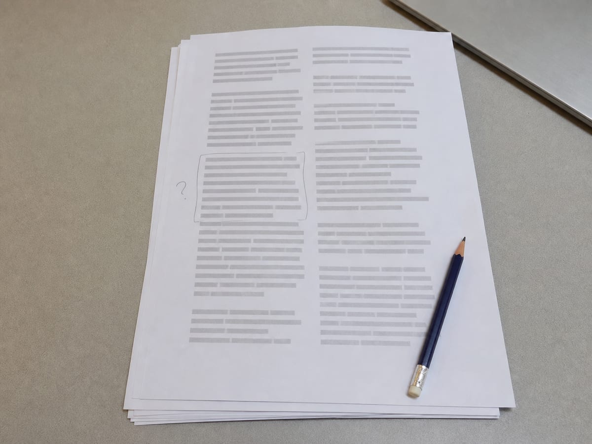 A single printed transcript on a desk with one short paragraph bracketed in pencil and a question mark in the margin